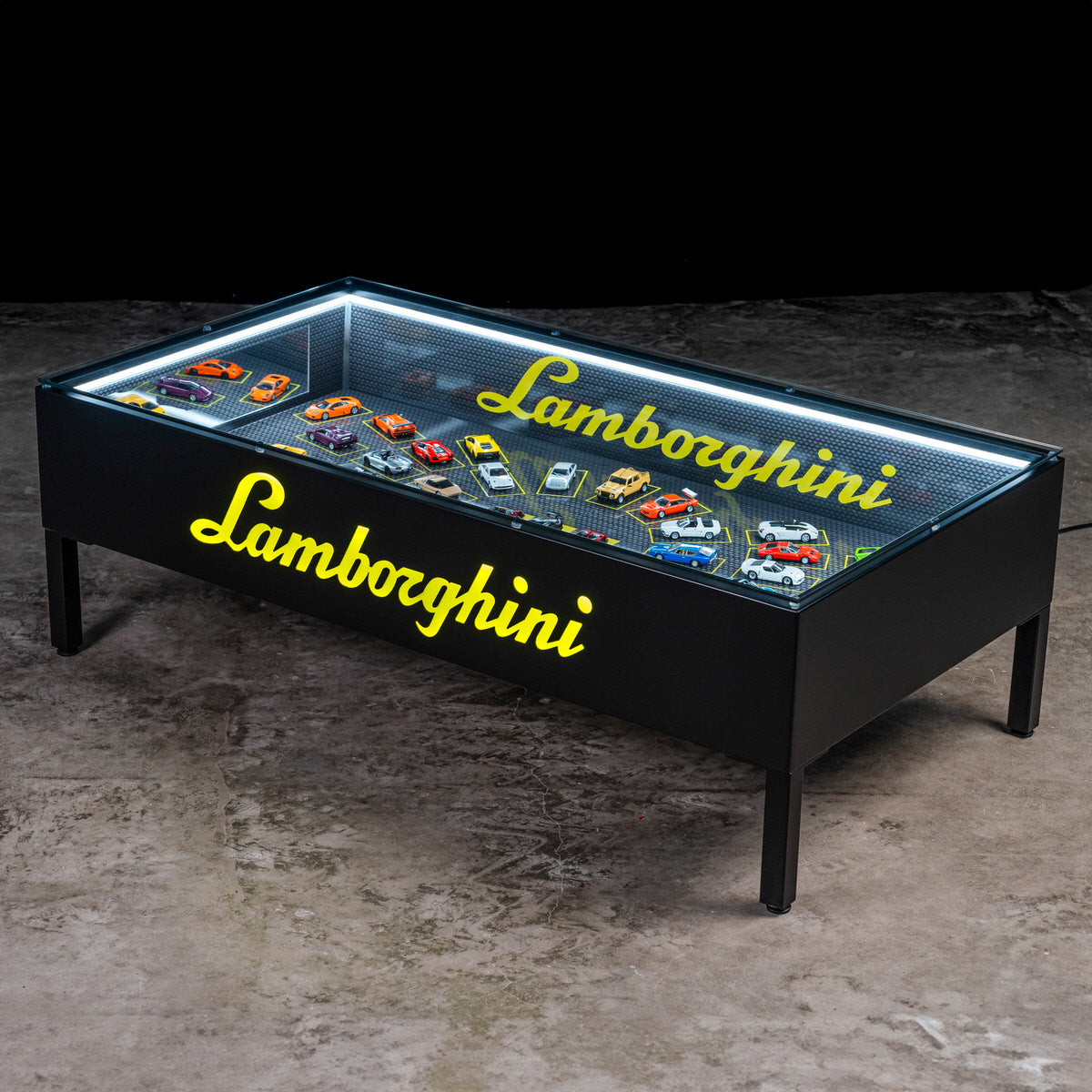 Lamborghini scale model table with glass top. / Tavolo con modellini Lamborghini e piano in vetro