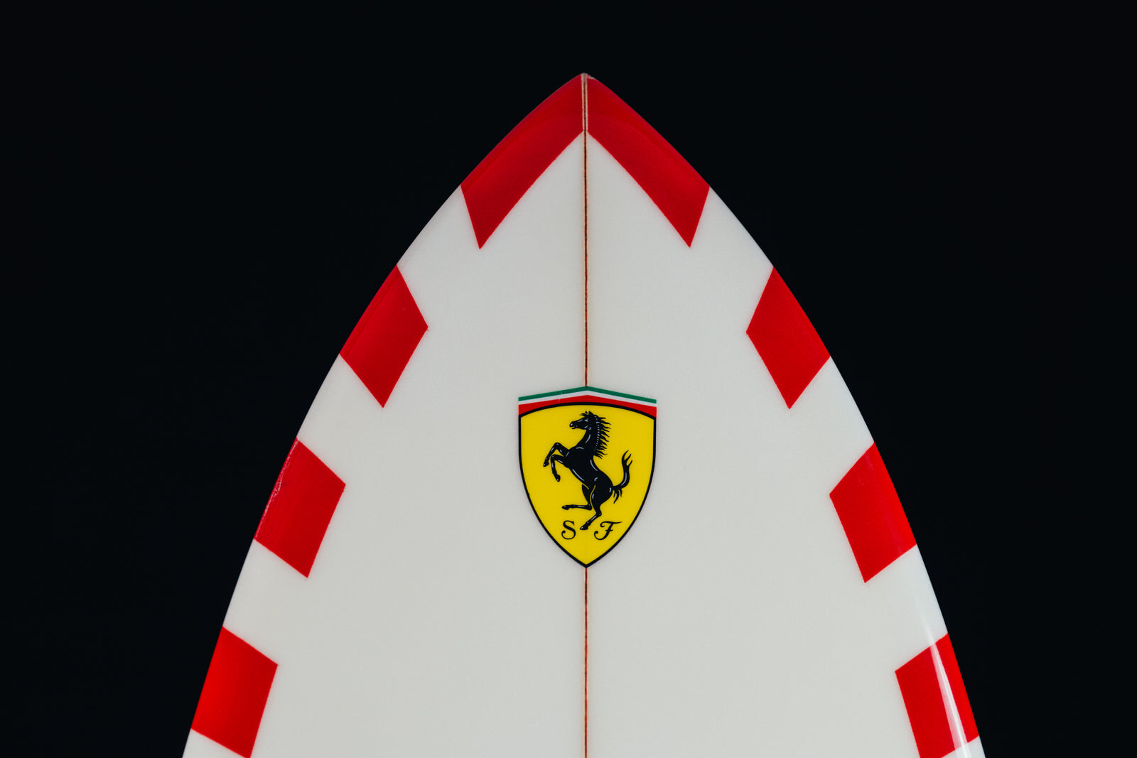 Close-up of the Ferrari surfboard with the Cavallino Rampante emblem and tricolor livery. / Dettaglio della tavola da surf Ferrari con emblema Cavallino Rampante e livrea tricolore.